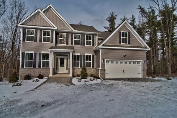 Jamison home front exterior with light grey siding, 2 car garage, light snow